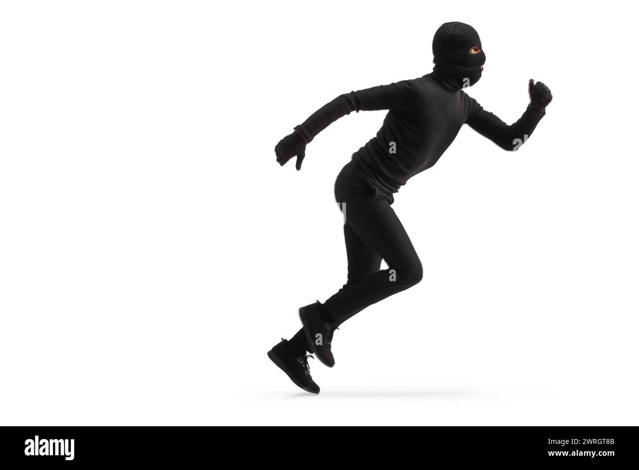 Full length profile shot of a thief in black clothes and balaclava running isolated on white background Stock Photo