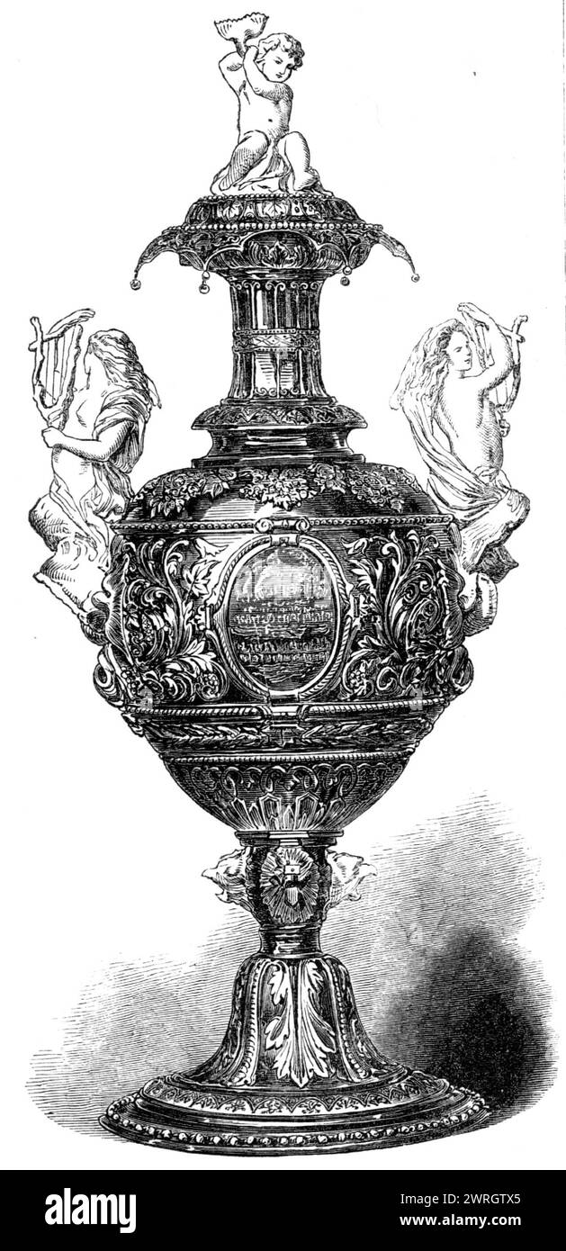 Royal Victoria Yacht-Club Regatta: the Commodore's Cup, 1864. 'This cup...was manufactured by Messrs. London and Ryder, goldsmiths, of 17, New Bond-street. The design is of the classic Greek style, the ground being dead gold and the relief dead silver. The two handles are beautifully-modelled mermaids, by Flaffern; the cover is frosted silver, surmounted by an infant Neptune astride on a dolphin. On the base are masks of sea monsters. The cup bears the following inscription: &quot;Presented to the Royal Victoria Yacht Club, by Charles Thellusson, Esq. - Ocean Match, Ryde to Torquay, August 16, Stock Photo
