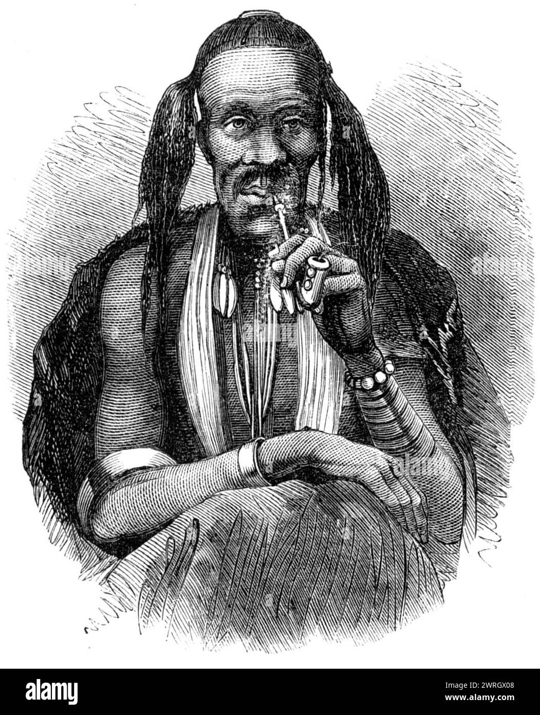 'A kaffir witch doctor, 1864'. Engraving from a photograph sent by Mr. S. D. Mandy. 'The Kaffir tribes of British Kaffraria, as well as those in other parts of South Africa, have a large body of native doctors residing amongst them, who exercise great influence over the people, and in whom all the Kaffirs are in the habit of placing implicit confidence for their treatment of the sick. The Kaffirs, indeed, are a doctor-loving people; their doctors and prophets form part of the machinery of them government, which is upheld by their feeling of devout and superstitious obedience...The Kaffir docto Stock Photo