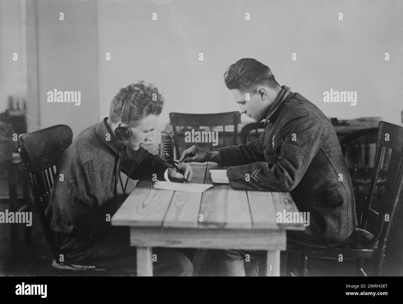 Telegraph lesson - crippled soldiers, 06 Feb 1919. Two soldiers, amputee veterans of World War I, leaning to use a telegraph at a vocational school for wounded soldiers at Walter Reed Hospital, Washington, D.C. One soldier lost an arm and the other a hand. Stock Photo
