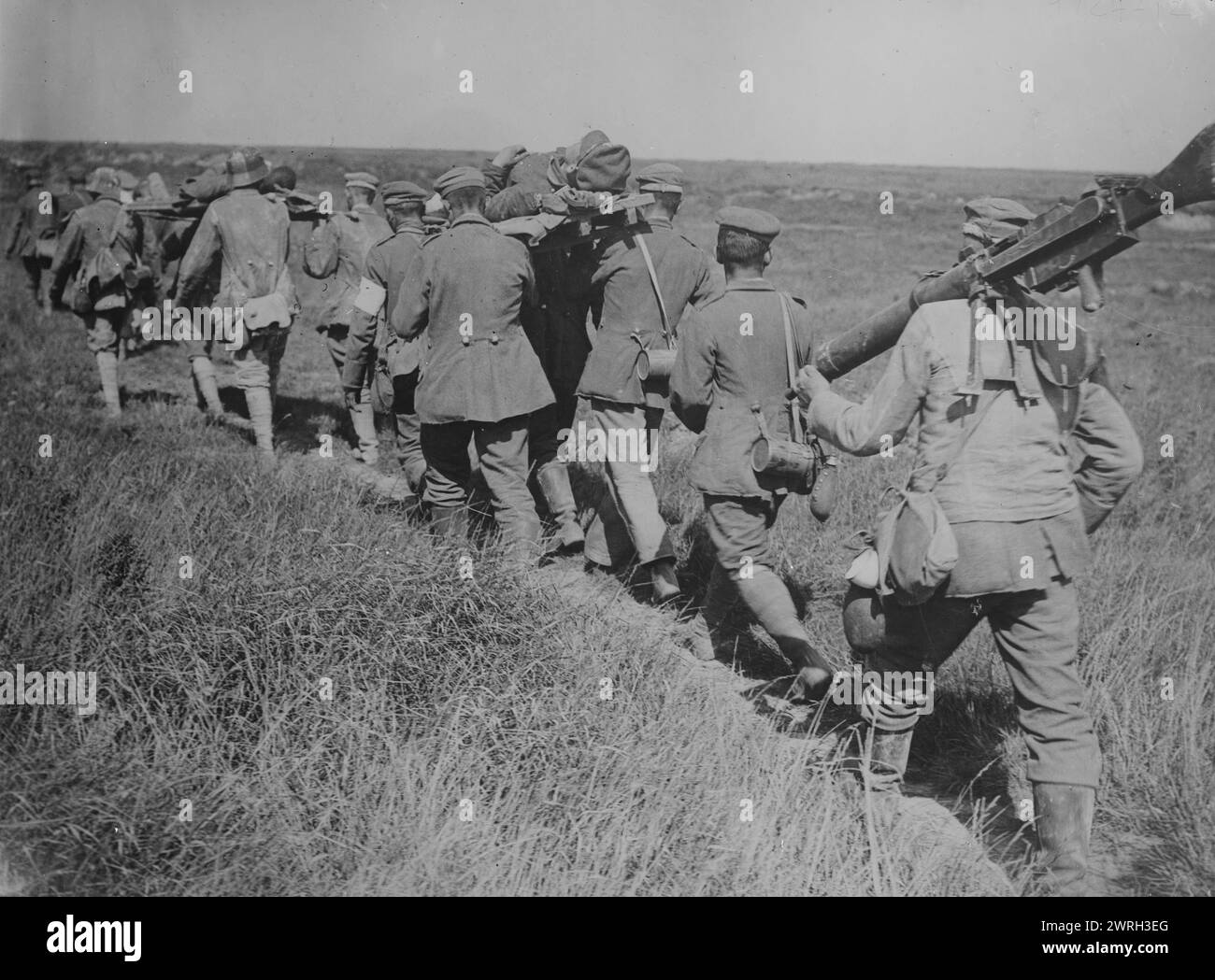 German prisoners with machine guns &amp; wounded, 21 Aug 1918. German prisoners bringing in wounded soldiers and captured machine guns during the third Battle of the Albert, near Courcelles, France, August 21, 1918 during World War I. Stock Photo