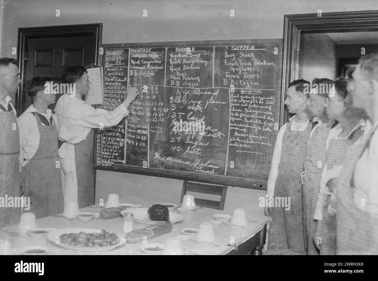 Recipes, Naval cooking school, 59th St. N.Y., between c1915 and 1918. Students looking at a blackboard on which are written recipes for rye bread and other foods, at the New York Cooking School, 126 East 59th Street, which trained soldiers to cook for the Navy during World War I. Stock Photo
