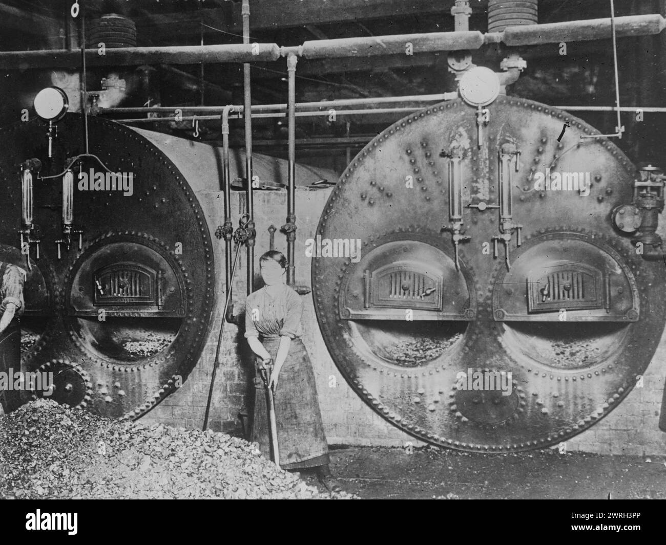 English furnace woman in iron works, between c1915 and 1917. A woman stoker England in front of a furnace at an ironworks during World War I. Stock Photo