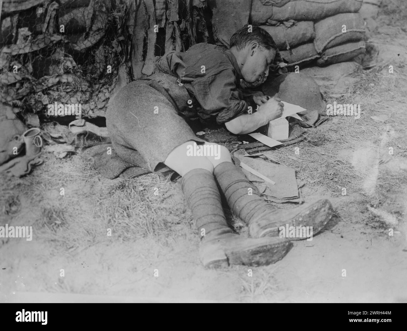 Tommy writing home after battle,  11 Jun 1917. A British officer, lying on the ground in a captured German trench in Oostaverne Wood, Belgium, writing a letter, during the Battle of Messines offensive, during World War I. Stock Photo