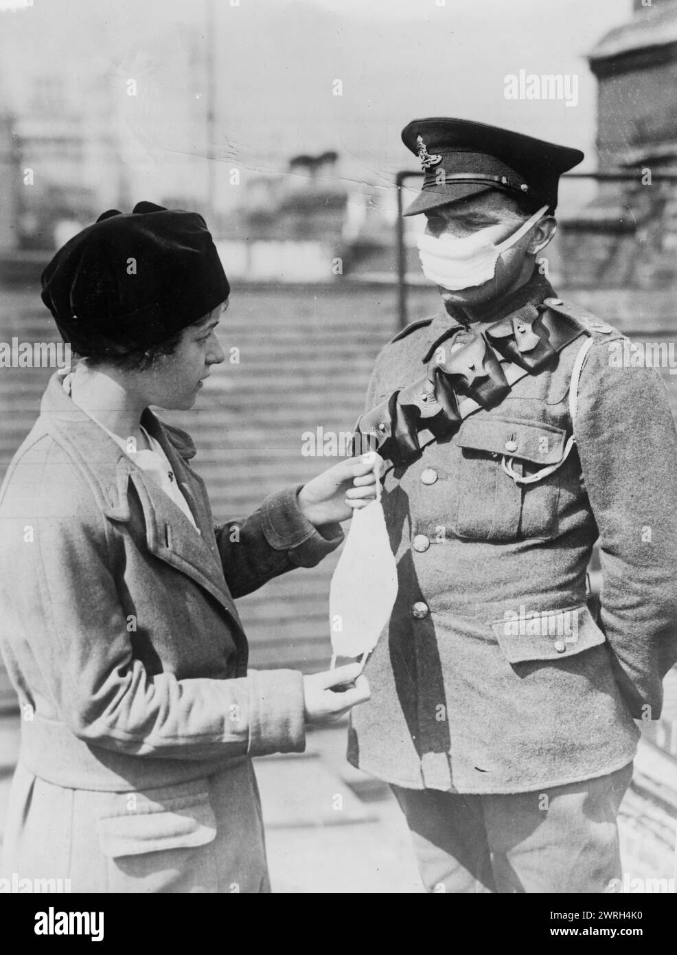 Respirator for British soldiers, between 1914 and c1915. A British soldier wearing a face mask to protect against poison gas, standing with a woman holding another face mask, during World War I. Stock Photo