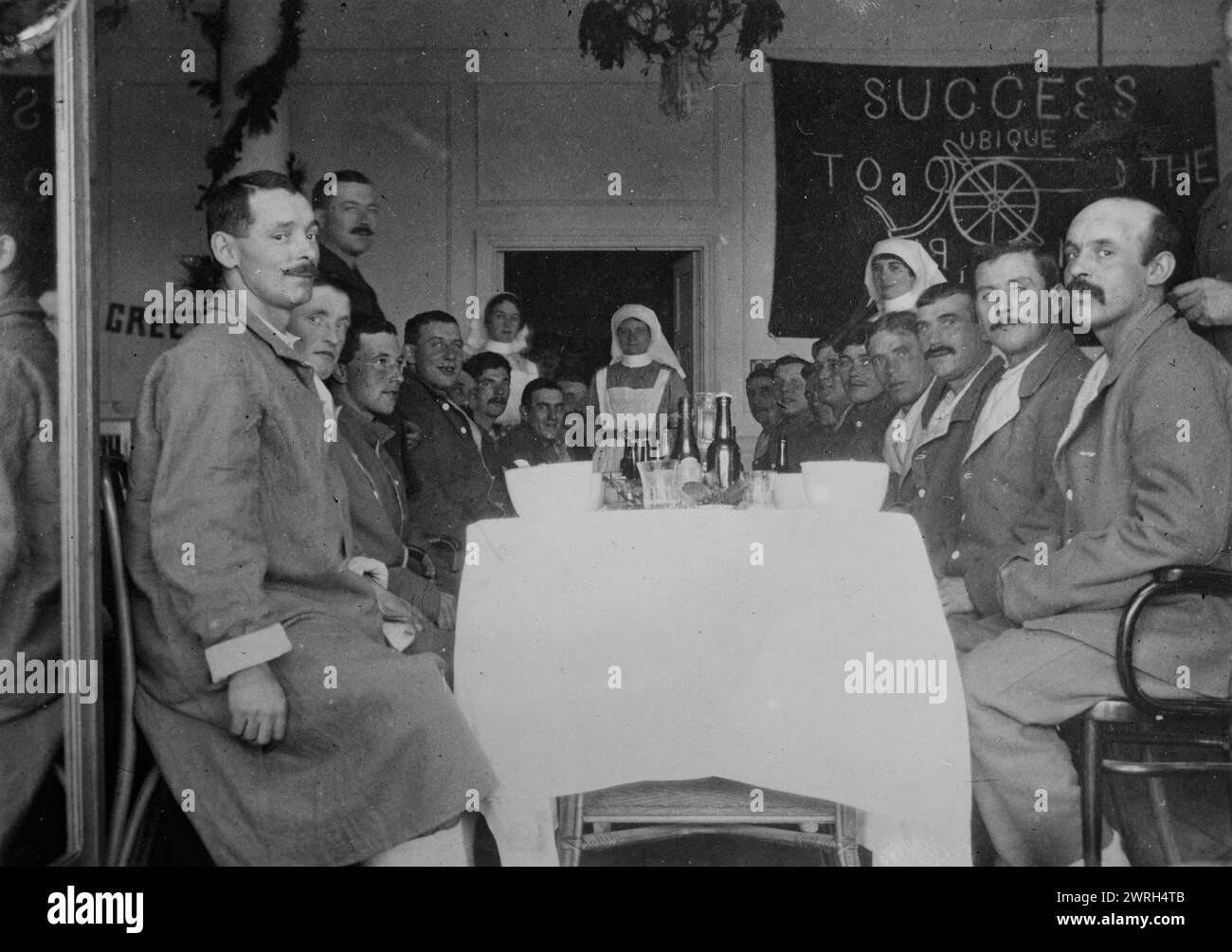 A spread in Nova Scotia ward, Le Touquet, between 1914 and c1915. Soldiers seated at a table in the Canadian base hospital in the Hotel du Golf, Le Touquet, France during World War I. A banner in the background is from the Royal Canadian Artillery. Stock Photo