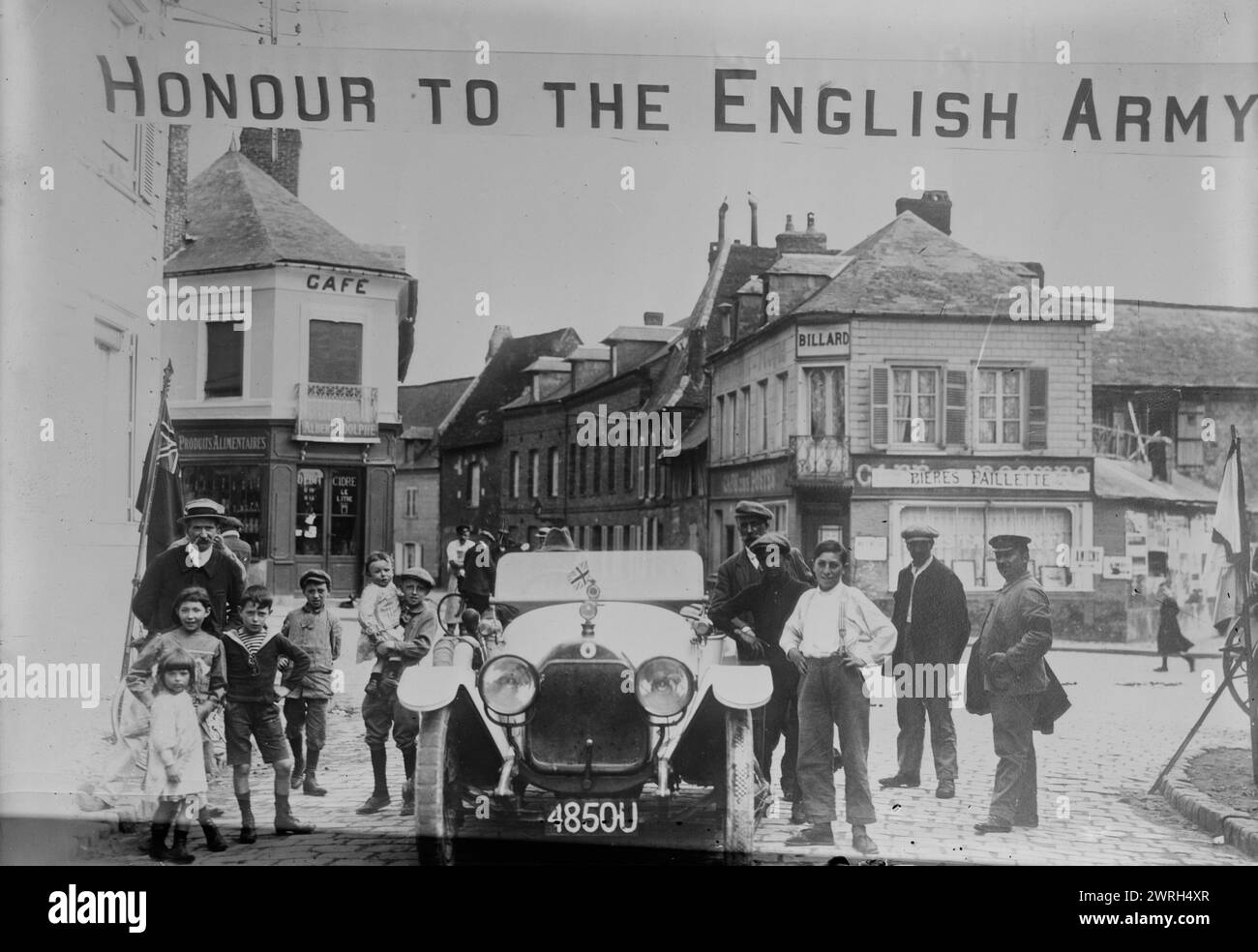Welcome to British, Boulogne, between c1914 and c1915. French people in street with an automobile with banner &quot;Honour to the English Army&quot; hung above them, during World War I, Boulogne-sur-Mer, France. Stock Photo