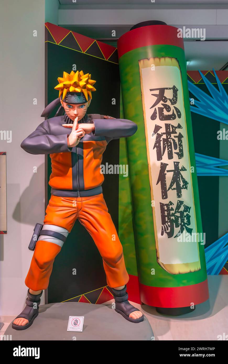 ikebukuro, japan - jan 16 2024: Life sized manga figurine of the ninja Naruto making a jutsu attack aside a scroll written 'Experience Ninja Martial A Stock Photo