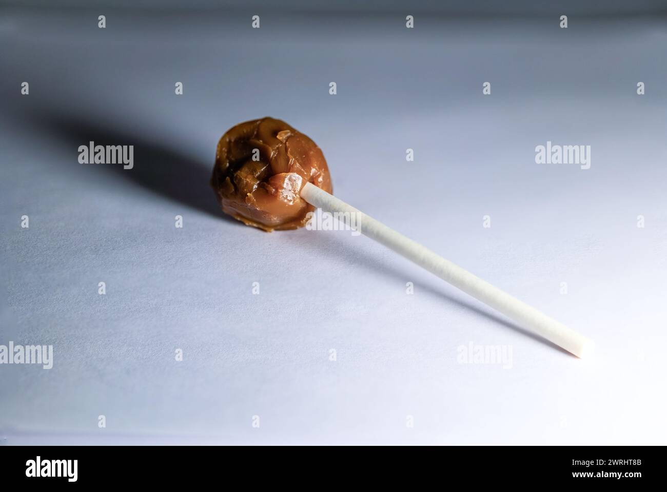 A mouthwatering chocolate lollipop with a smooth, glossy surface, captured in sharp focus on a white background Stock Photo