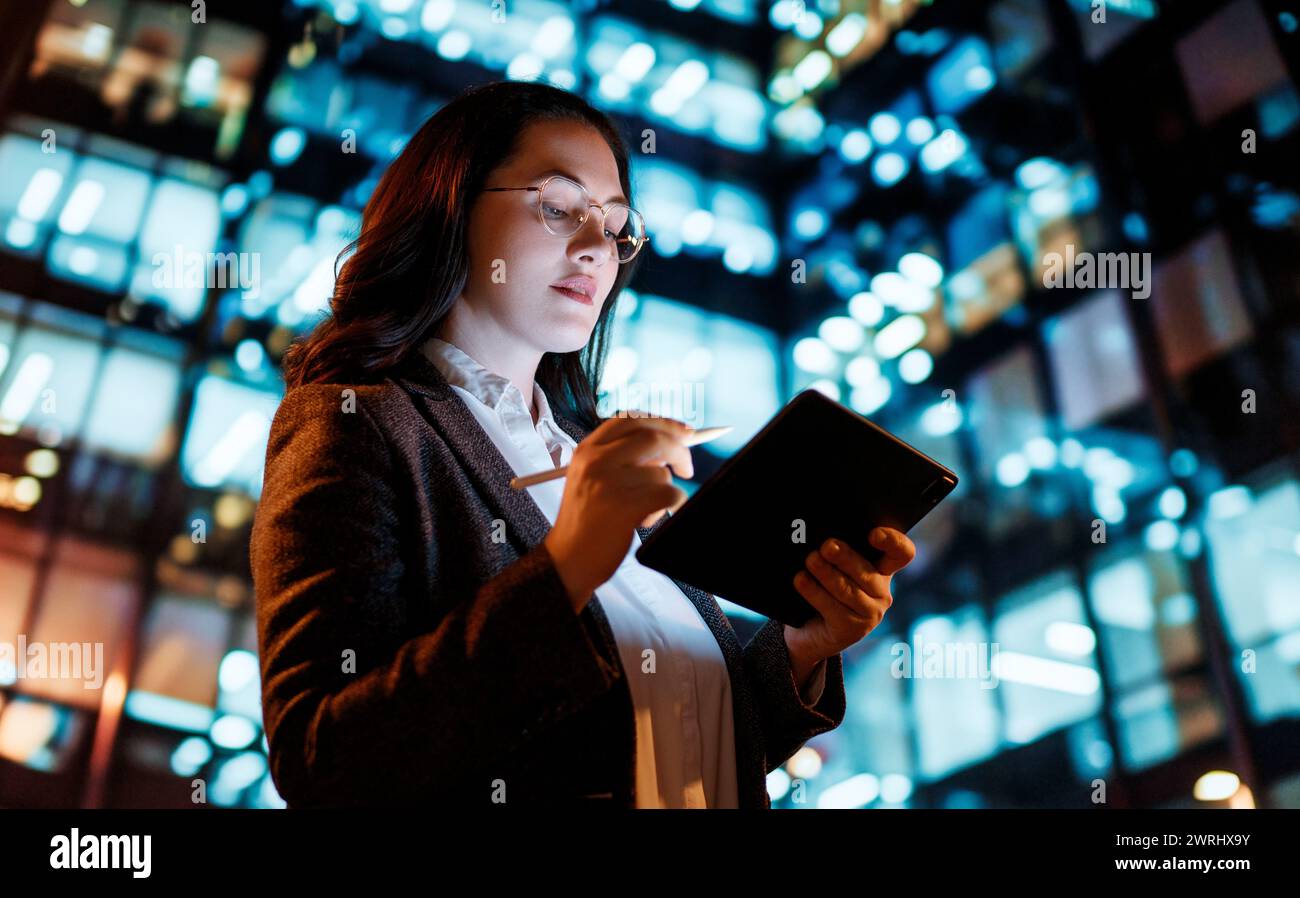 Young businesswoman using tablet pc in the city in the evening. Stock Photo