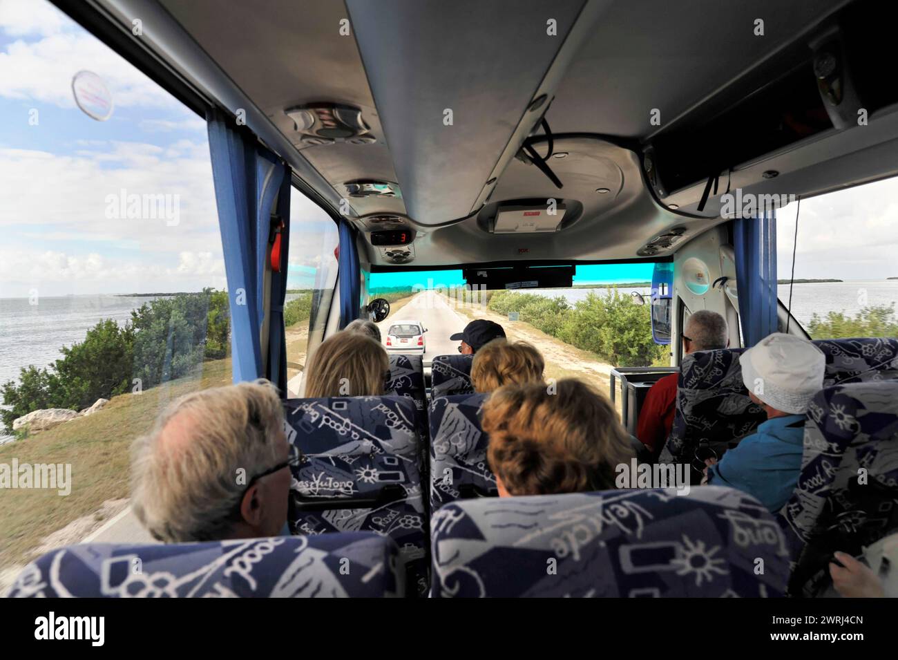 Passengers in a bus enjoy the view of the coastal landscape, Cuba, Central America Stock Photo