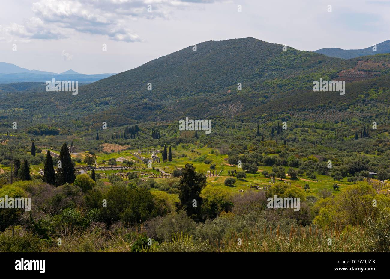 A peaceful landscape with green mountains, trees, farmland and a cloudy sky, view of Messene, ancient Greek polis, Messini, Messinia, Peloponnese Stock Photo