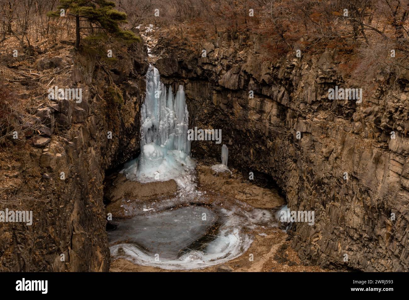 Looking down on frozen waterfall in deep crater located in Gyeonggi province of South Korea Stock Photo