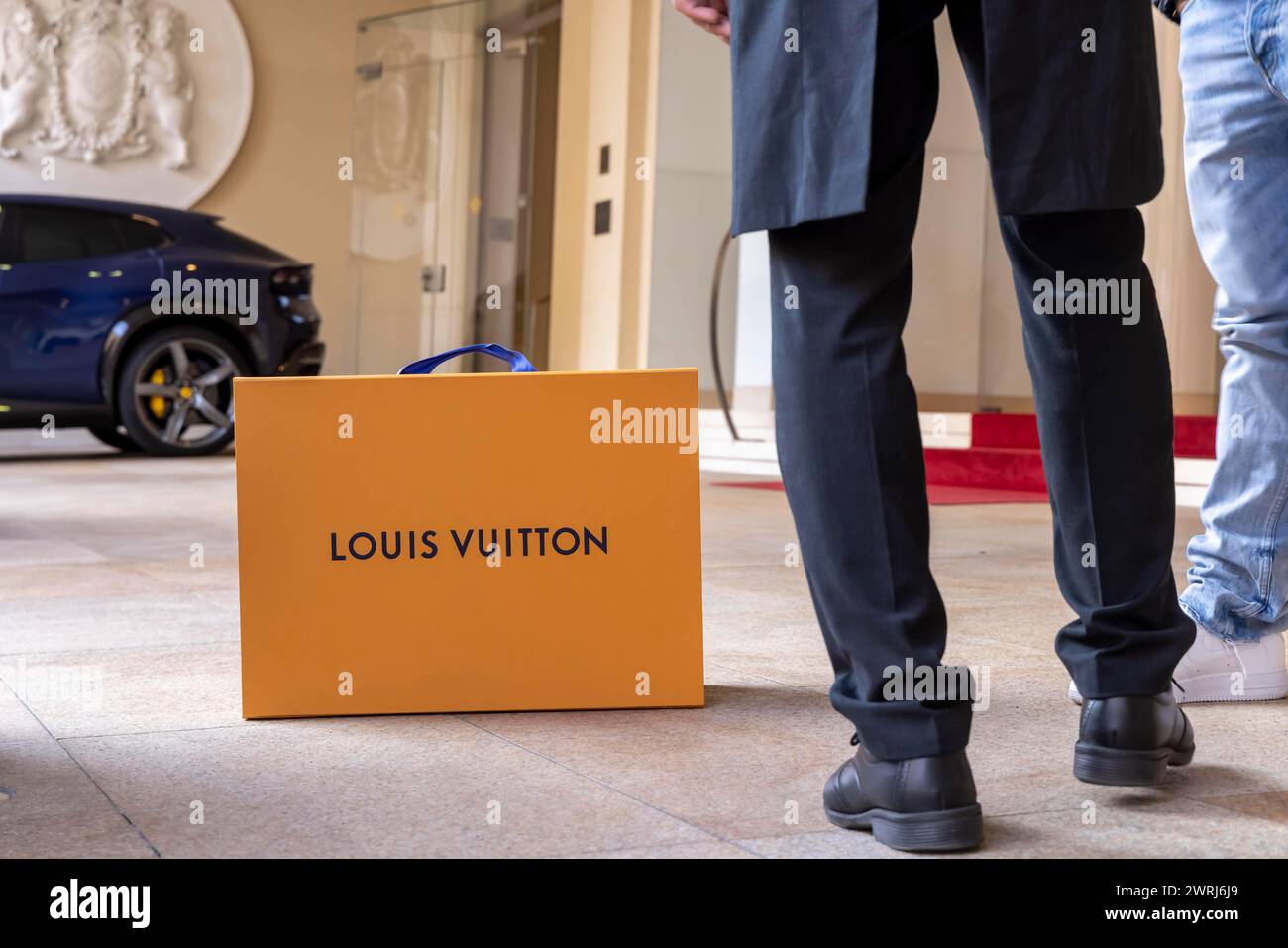 Shopping bag of the luxury brand Louis Vuitton, Hotel Vier Jahreszeiten Kempinski Munich with red carpet, Munich, Bavaria, Germany Stock Photo
