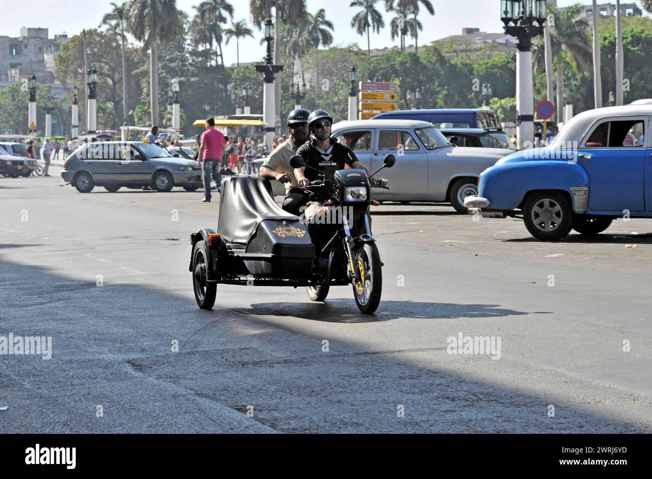 Motorbike with sidecar riding on a busy city street, Havana, Cuba, Central America Stock Photo