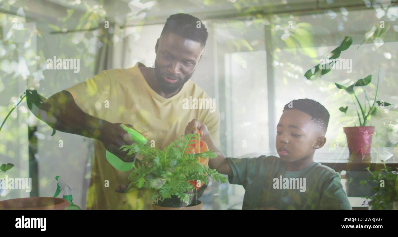 Image of leaves over happy african american father and son watering ...