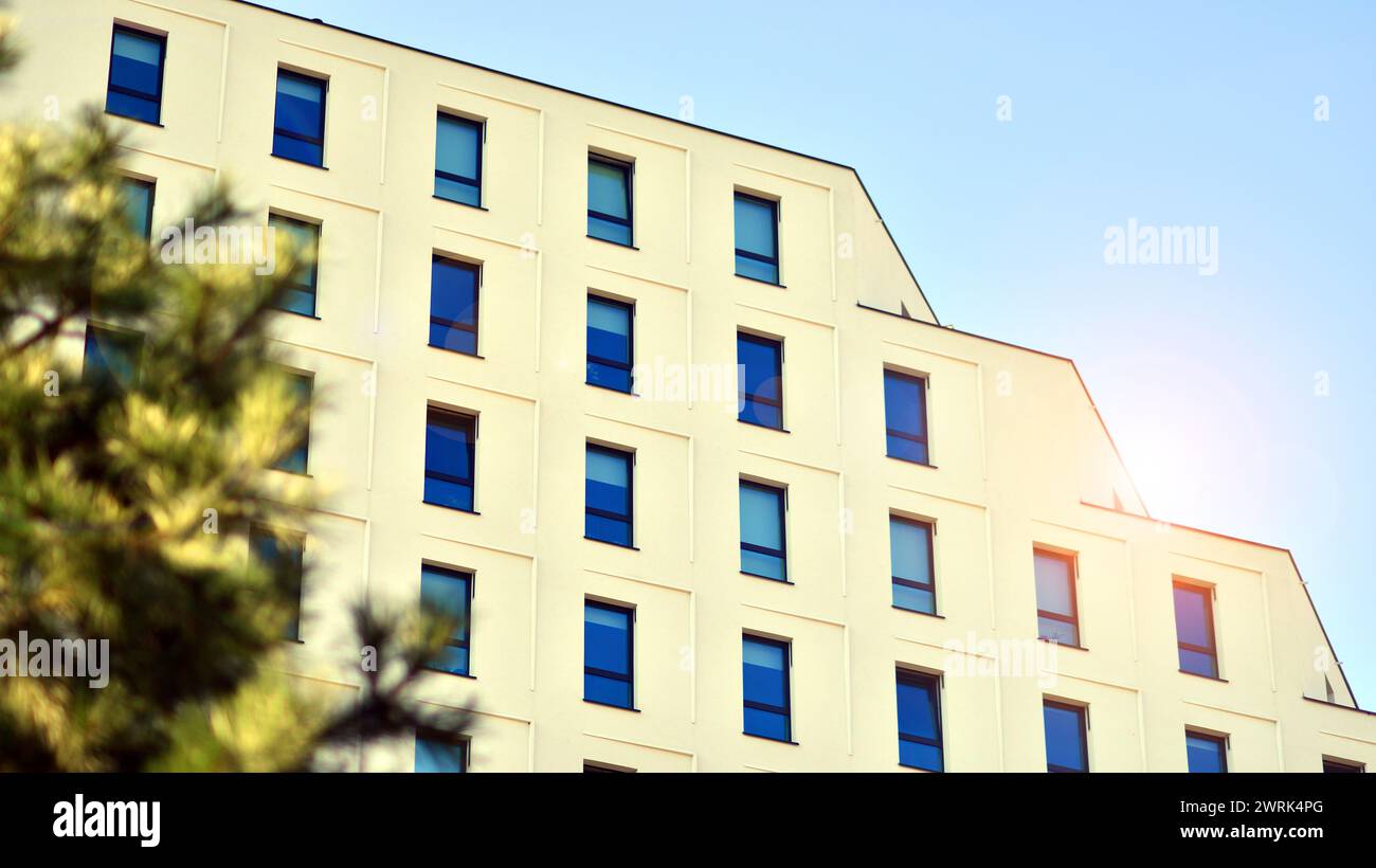 Image showcasing View of a white modern apartment building. Perfect symmetry with blue ...