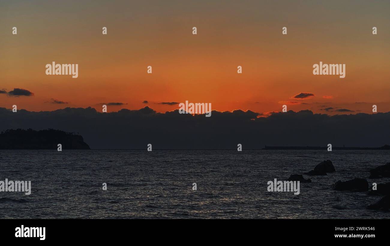 The sun setting over the ocean Stock Photo