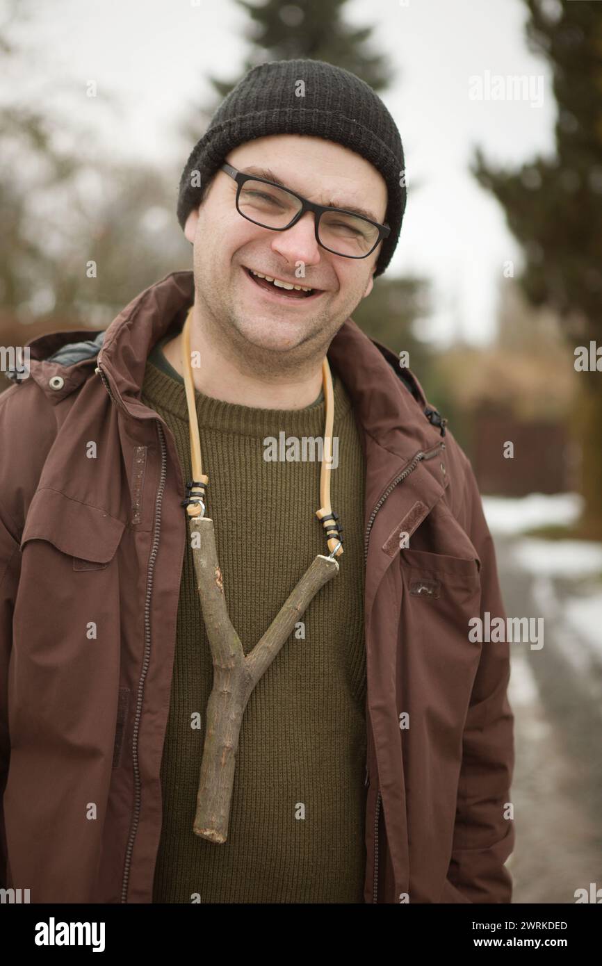 Adult man in winter time outdoor with home made slingshot Stock Photo