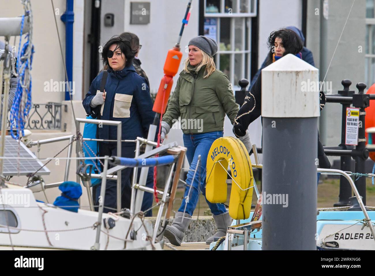 Weymouth, Dorset, UK.  13th March 2024.  Apple TV Irish black comedy television series Bad Sisters developed by Sharon Horgan, Dave Finkel, and Brett Baer, is filming at Weymouth harbour in Dorset with Sarah Greene as Bibi Garvey, Eva Birthistle as Ursula Flynn and Eve Hewson as Becka Garvey, who are doing scenes on the harbourside and on yacht called Grand Cru.  Picture Credit: Graham Hunt/Alamy Live News Stock Photo