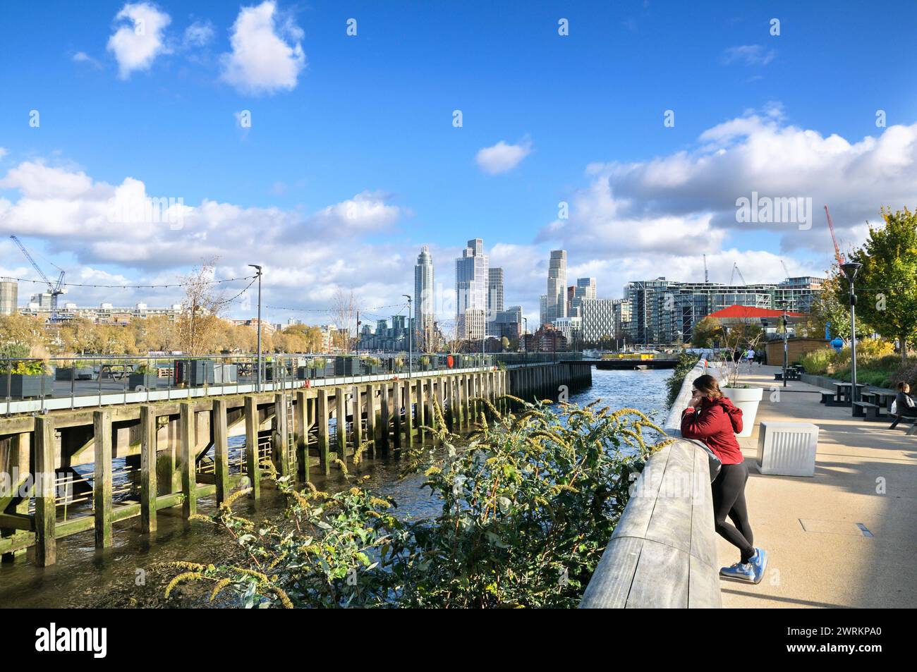 View of the River Thames outside Battersea Power Station with Coaling Jetty and high rise residential skyscrapers of Nine Elms and Vauxhall, London UK Stock Photo