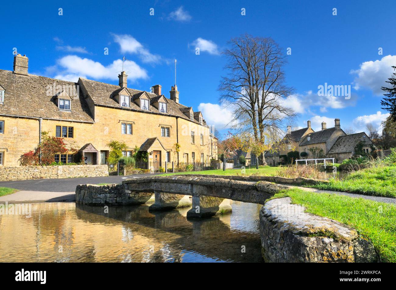 Cotswolds scene with traditional cottages and stone bridge over River Eye in picturesque Cotswold village Lower Slaughter, Gloucestershire, England UK Stock Photo