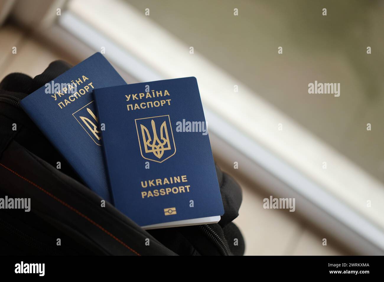 Two ukrainian biometrical passports on black touristic backpack close up Stock Photo