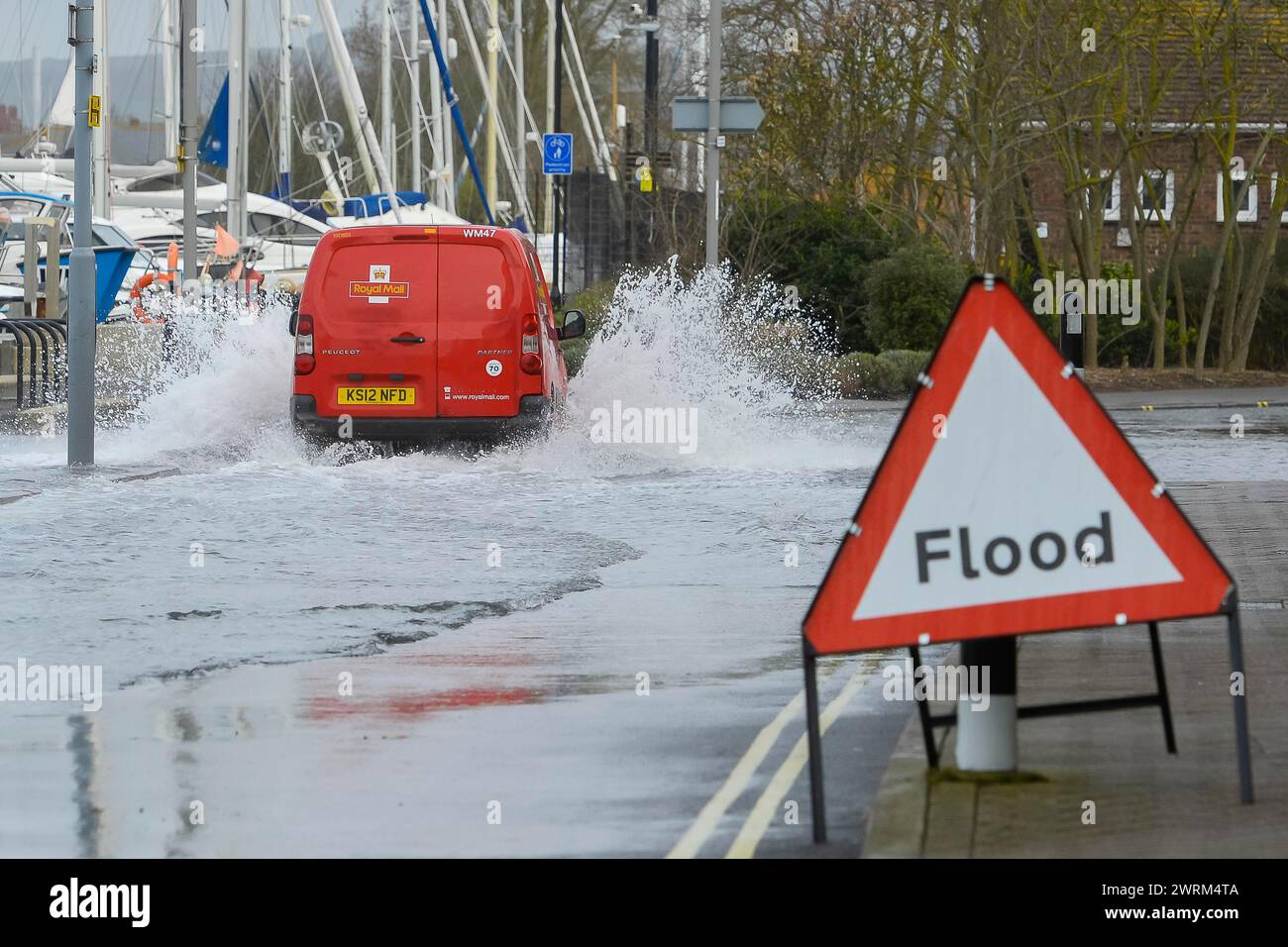 Weymouth, Dorset, UK.  13th March 2024. UK Weather:  A van drives through floodwater from a high spring tide on Commercial Road next to the harbour at Weymouth in Dorset on a warm overcast morning.  Picture Credit: Graham Hunt/Alamy Live News Stock Photo