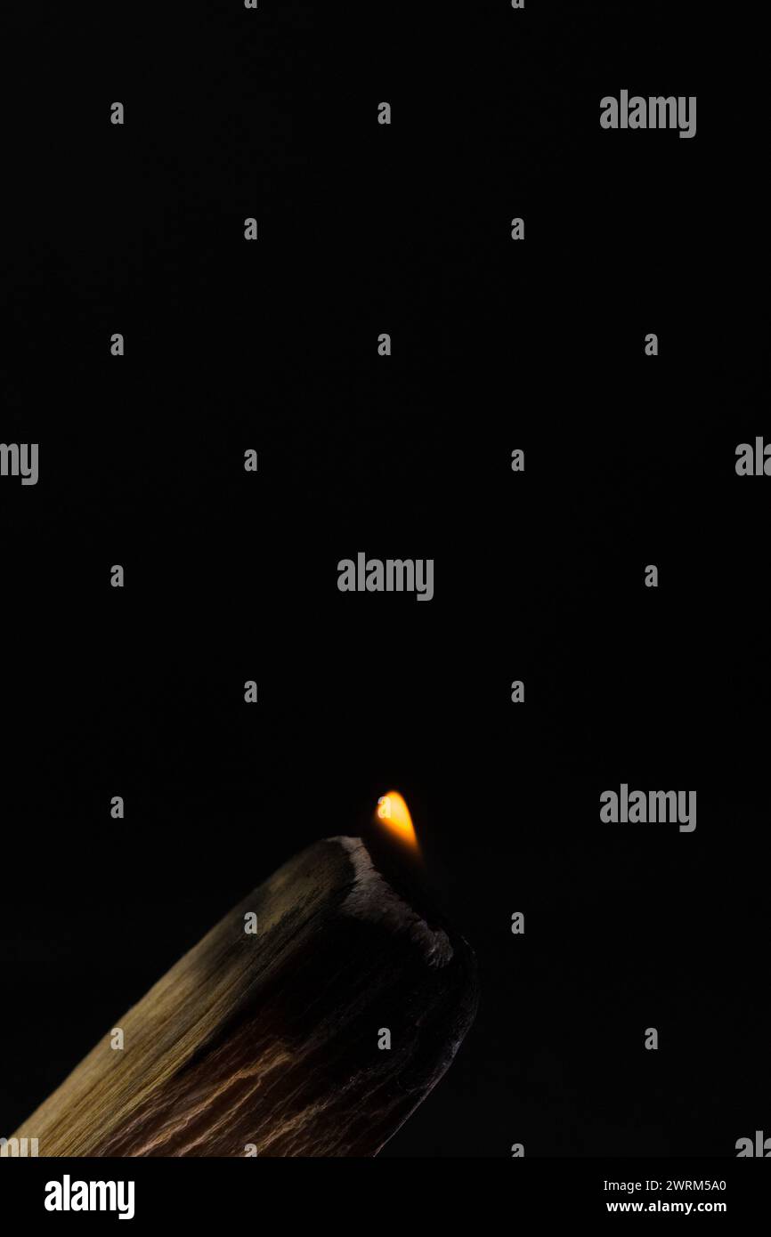 Palo santo burning with flame and smoke with dark background in ...