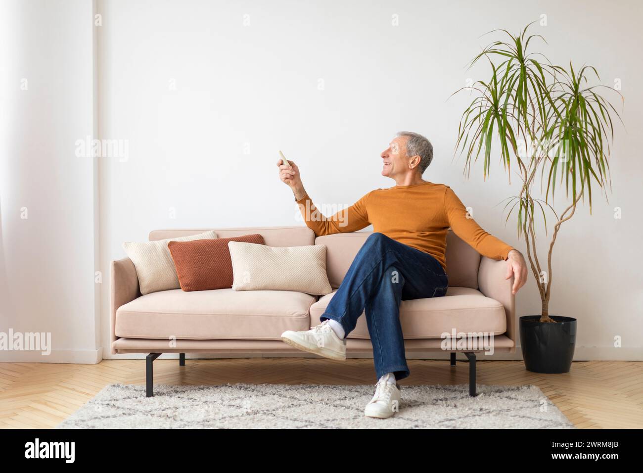 Happy senior man sitting sofa hi-res stock photography and images - Alamy