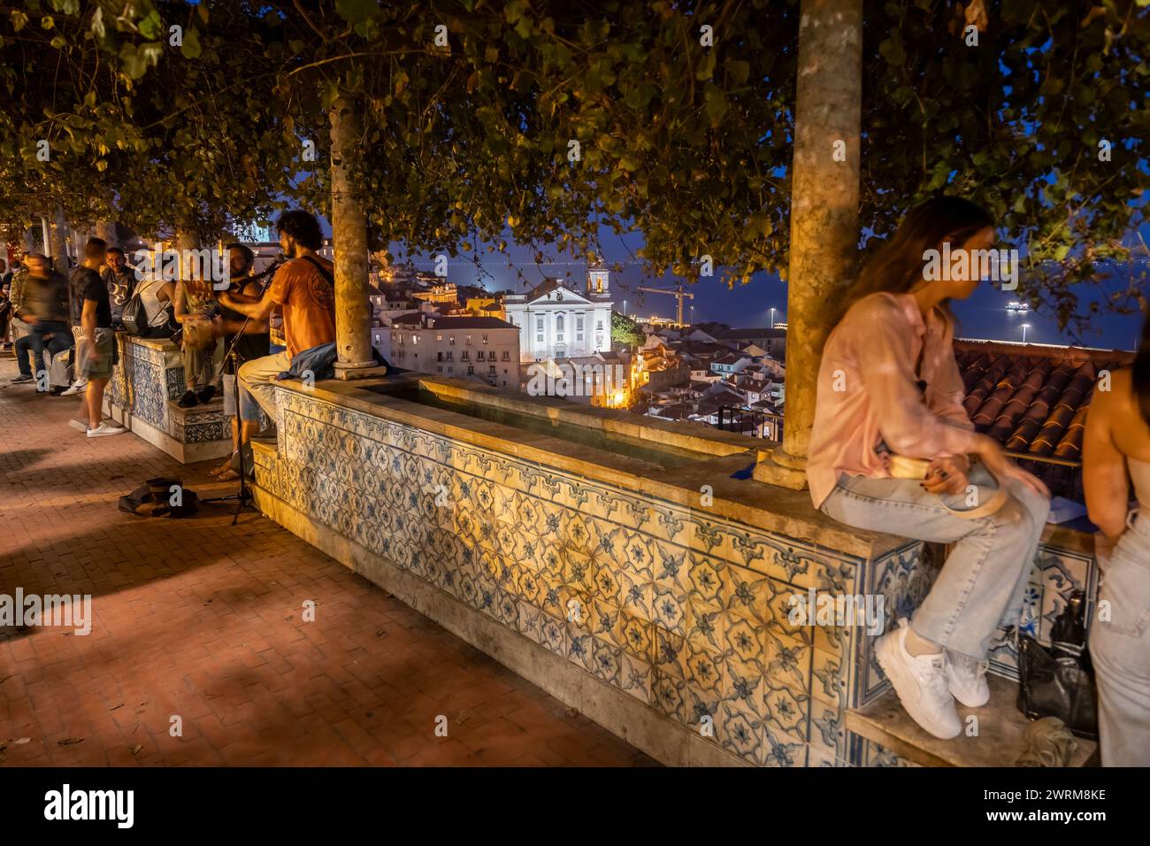 People at Miradouro de Santa Luzia at night in city of Lisbon, Portugal. Stock Photo
