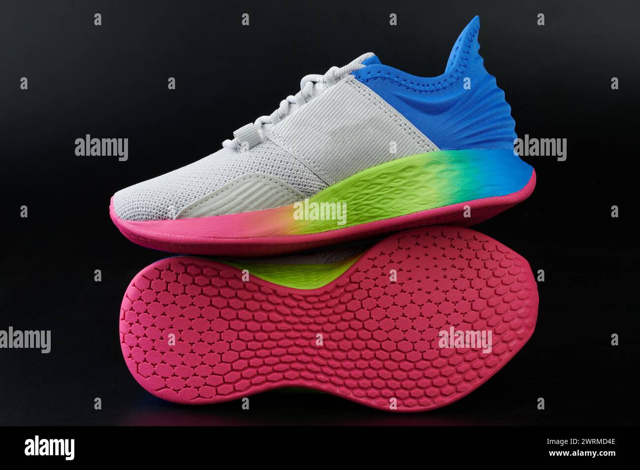 Trendy colorful light sport shoes with rainbow sole isolated on black studio background Stock Photo