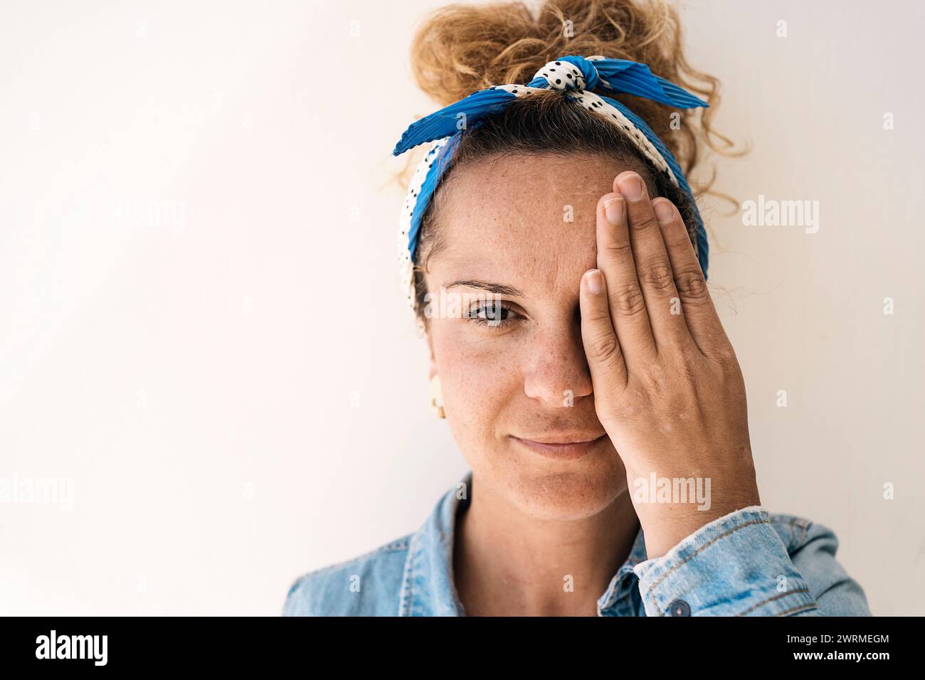 A portrait of a reflective woman with a headscarf and glasses, covering ...