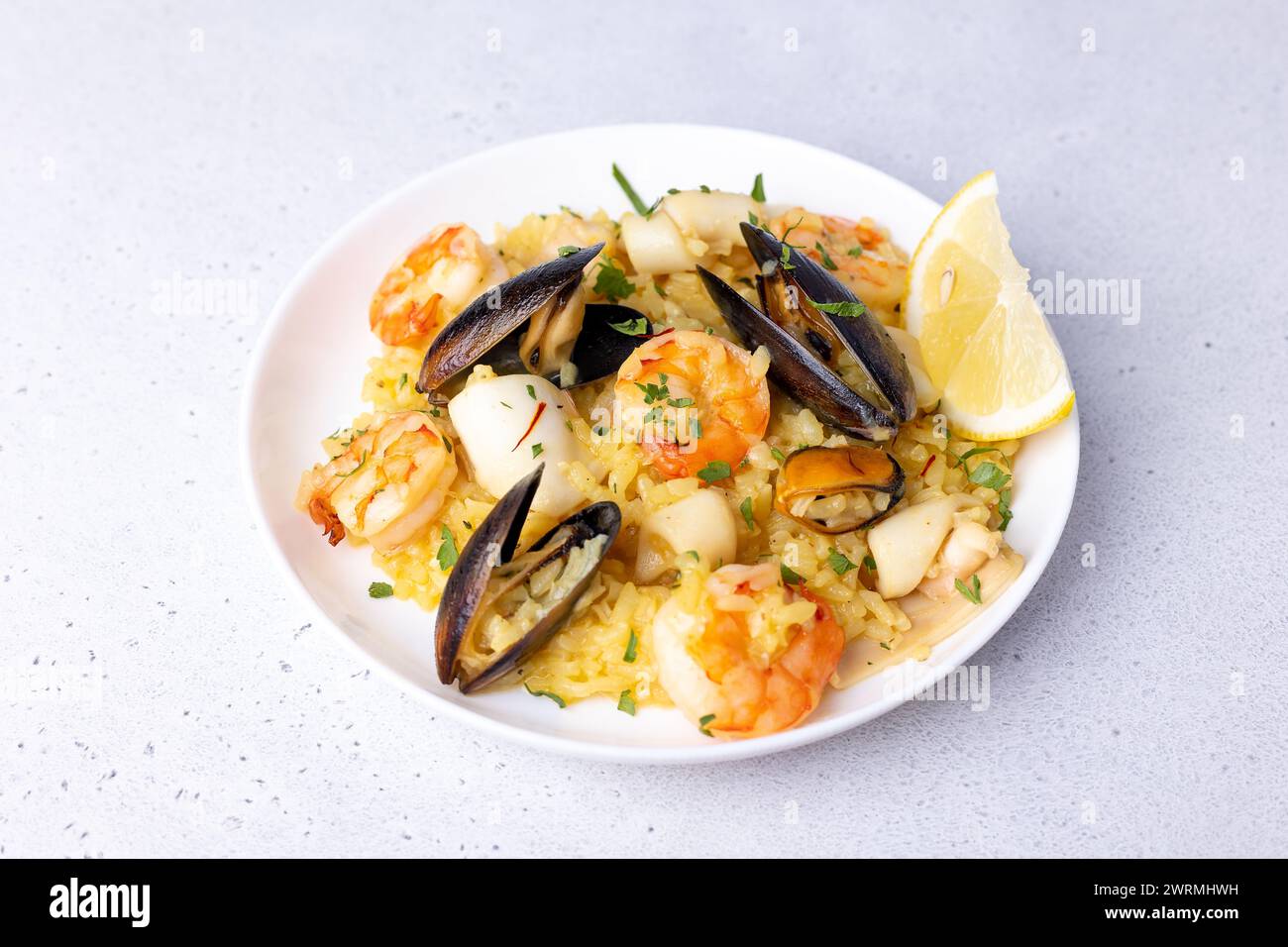 Seafood risotto with saffron, parsley and lemon. Arborio rice with