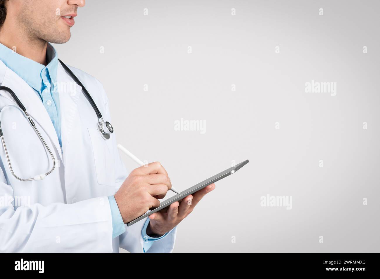 Focused man doctor using digital tablet, free space Stock Photo
