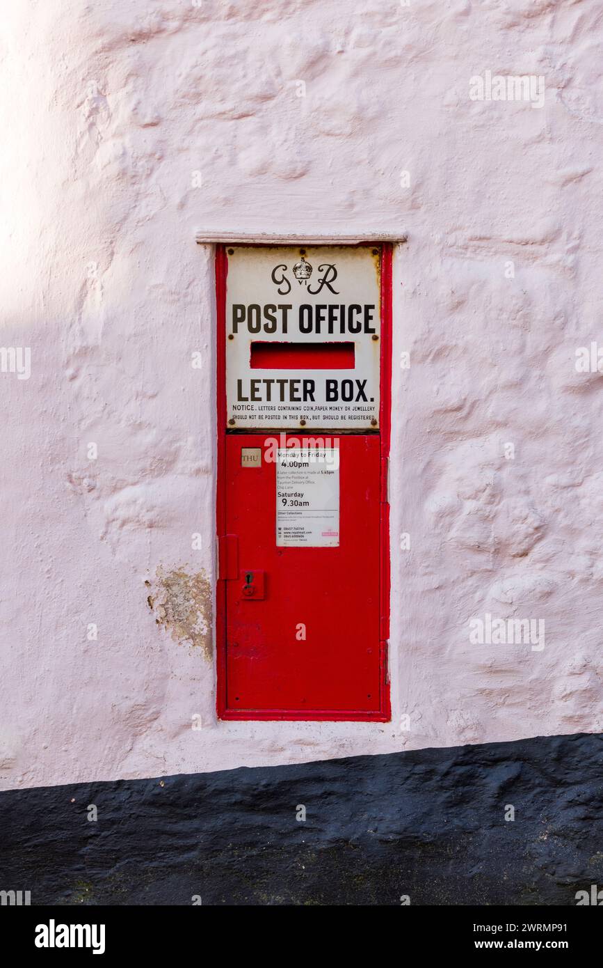 An old traditional red letterbox in the wall of a cottage in the rural village of Stogumber in Somerset, England. Stock Photo