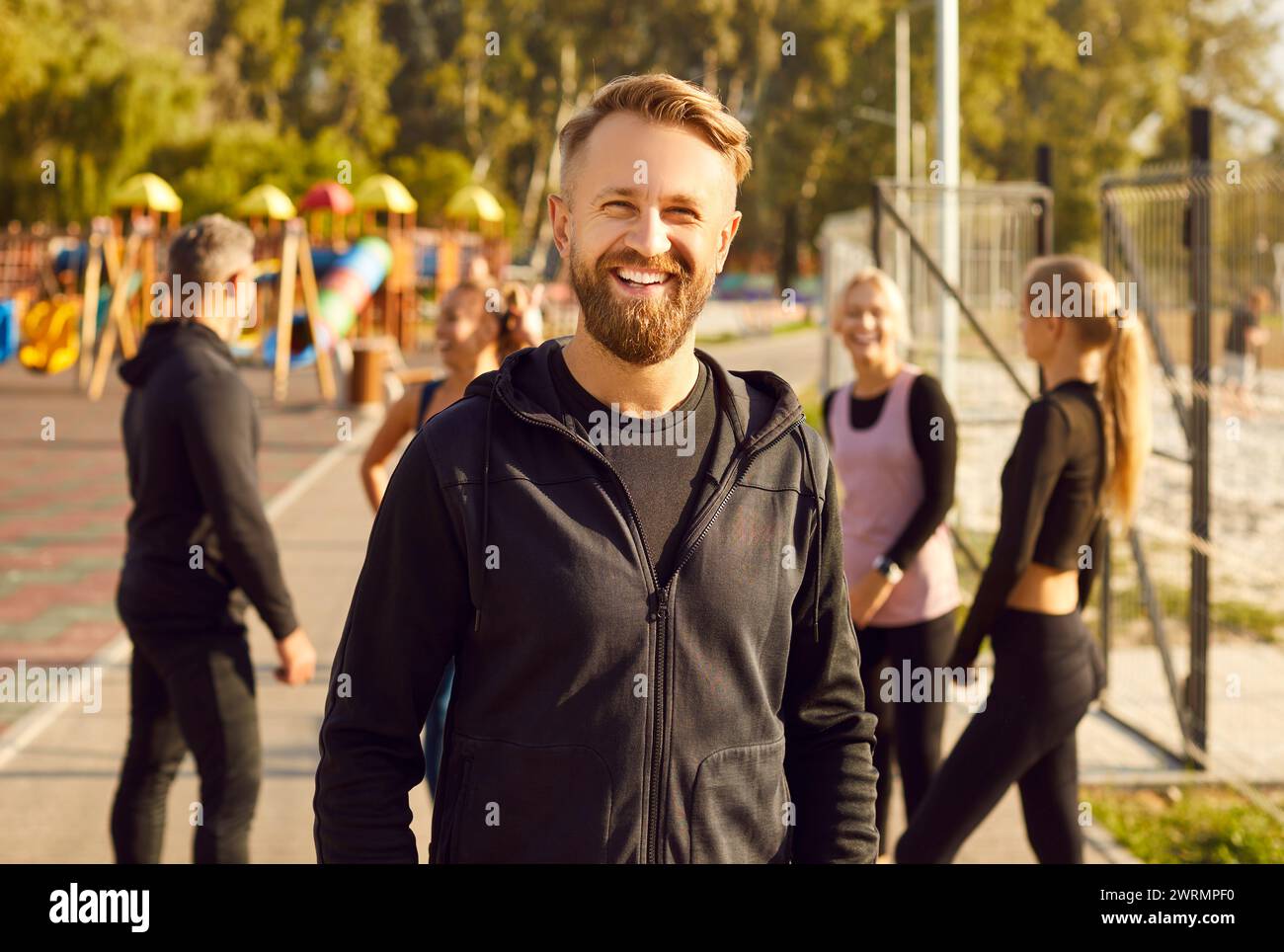 Portrait of happy sporty man looking at camera after fit exercises in nature in the park. Stock Photo