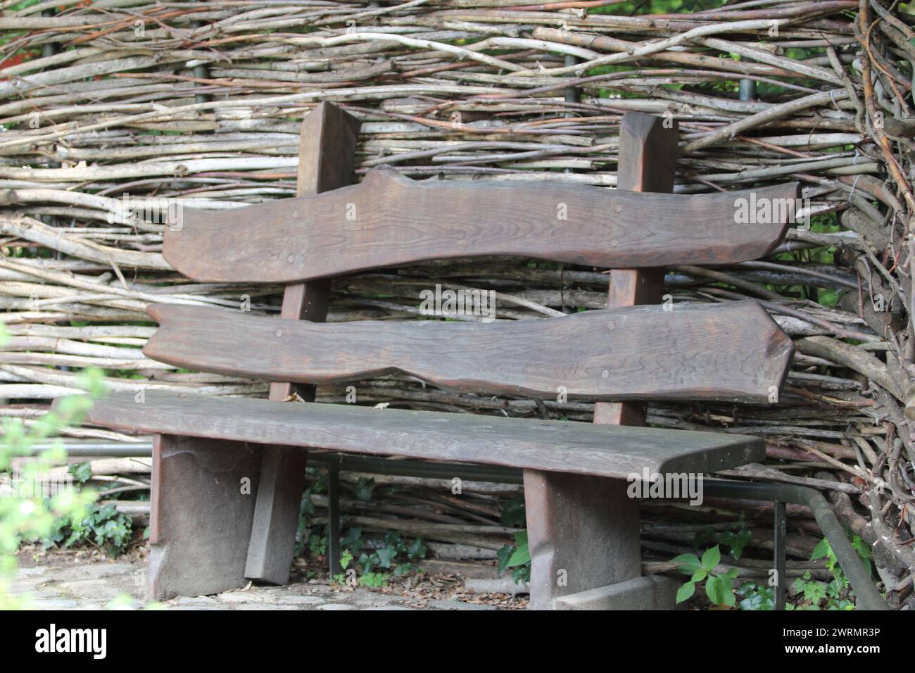 A wooden bench in front of a timber wall Stock Photo - Alamy
