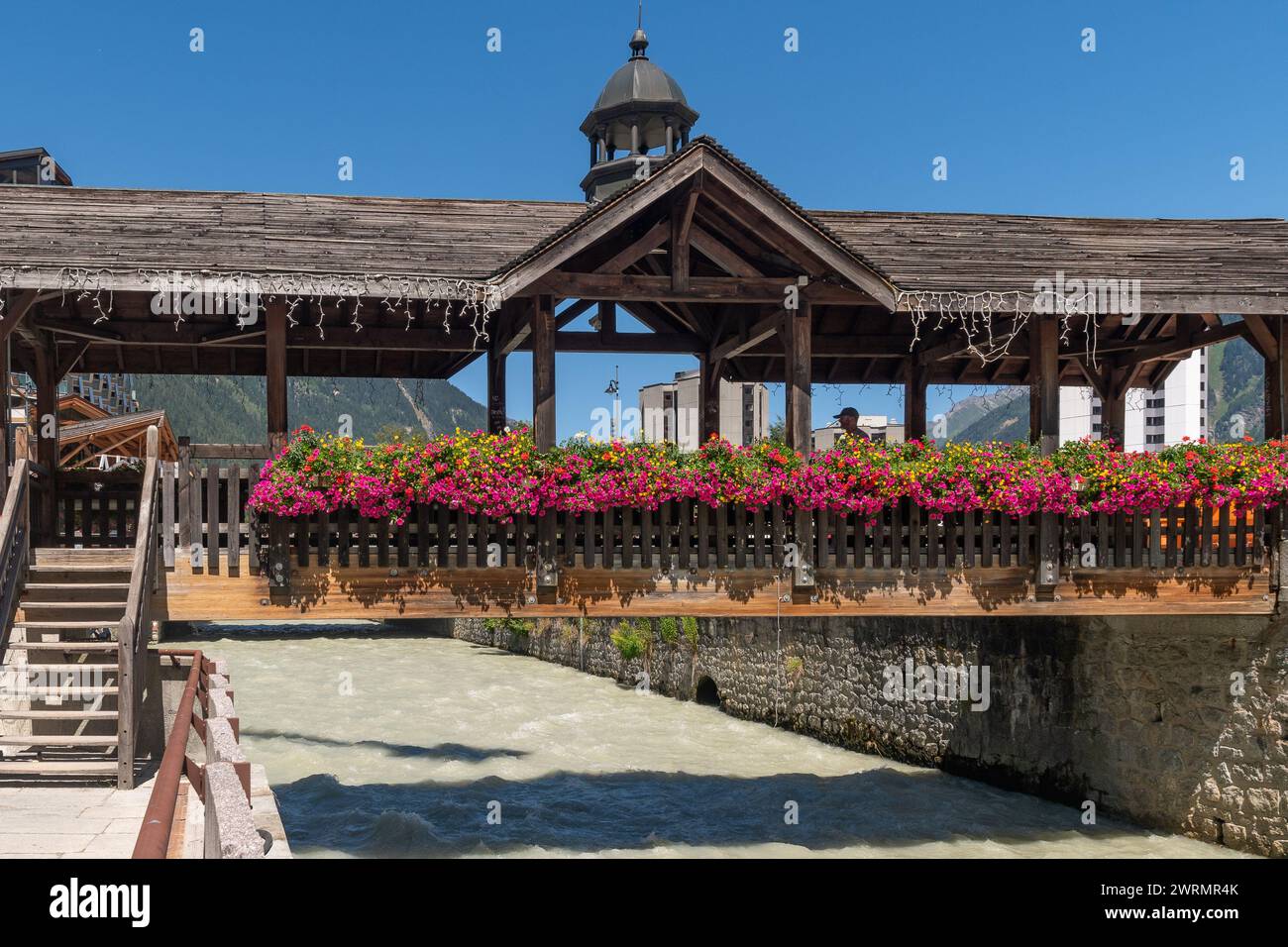 Wooden bridge decorated with flowering plants on the Arve River in the famous French ski resort in summer, Chamonix, Haute Savoie, France Stock Photo