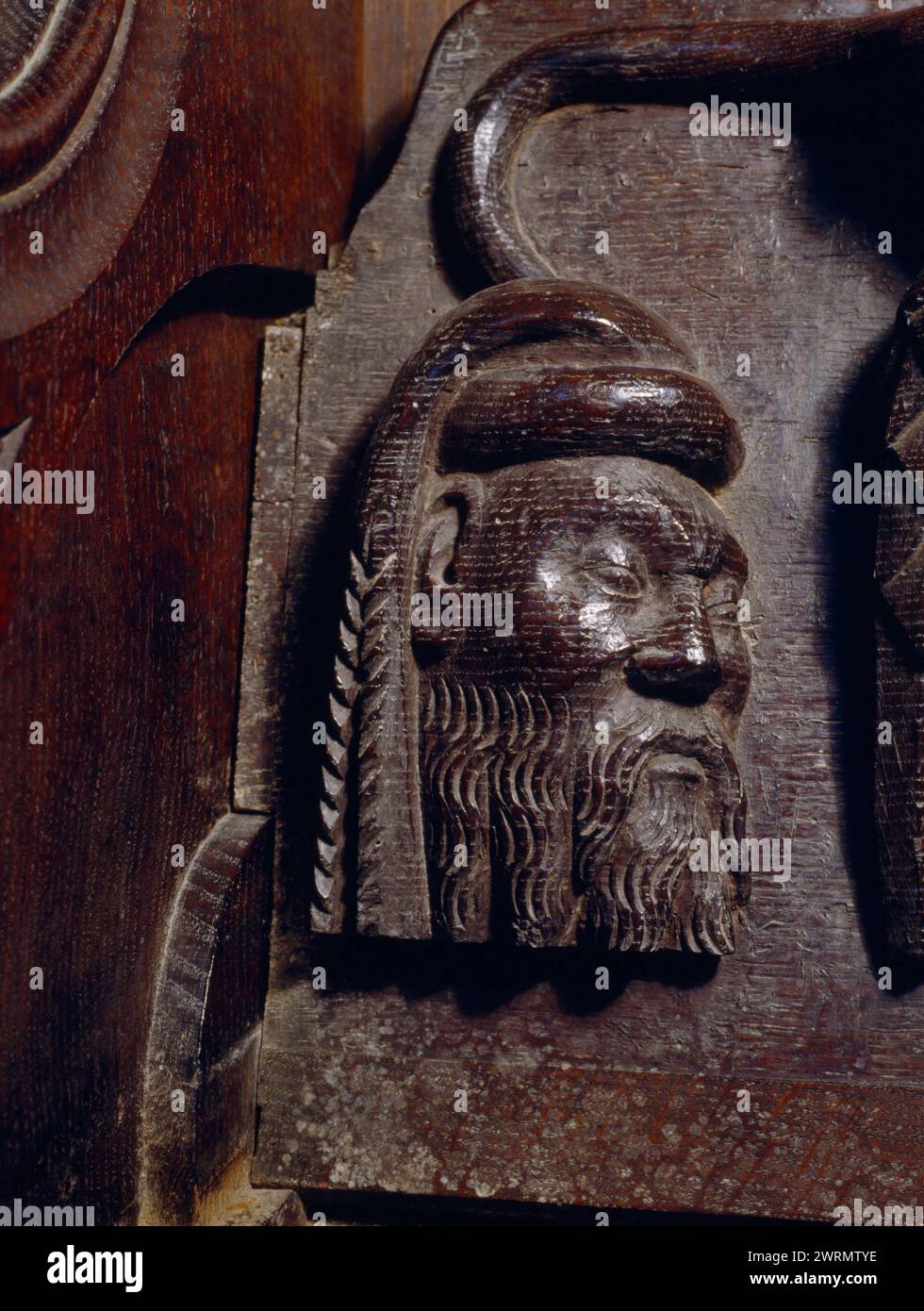 The head of a nobleman carved on the underseat of a misericord in the oak choir stalls in the chancel of Beaumaris parish church, Anglesey, Wales, UK. Stock Photo