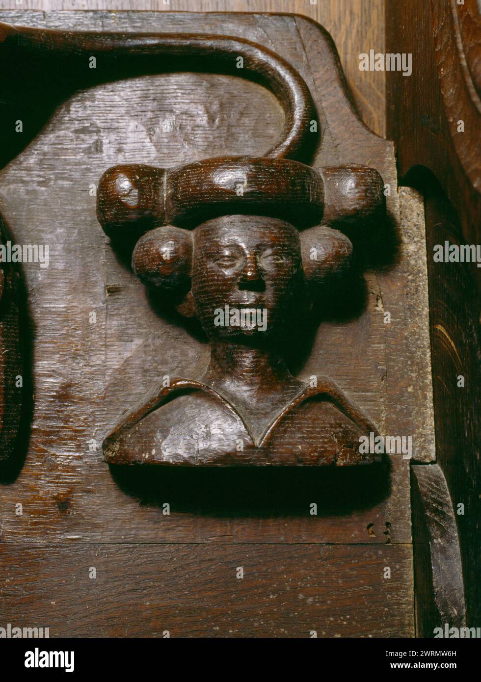 Bust of a young, stylish noblewoman carved on a misericord of the oak choir stalls in the chancel of Beaumaris parish church, Anglesey, Wales, UK. Stock Photo