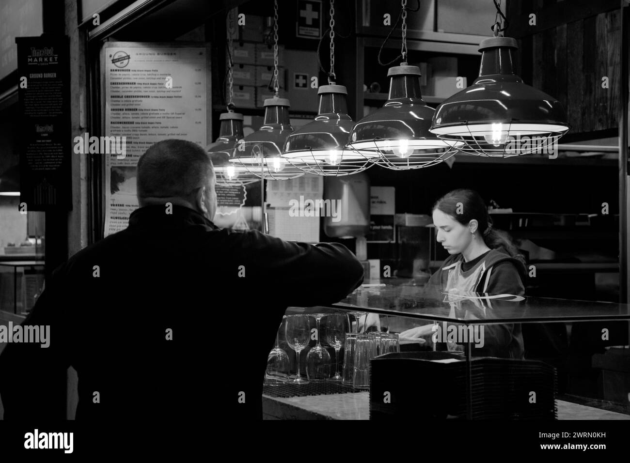 Barmaid serves aperitifs at Mercado da Ribeira in Lisbon, Portugal Stock Photo