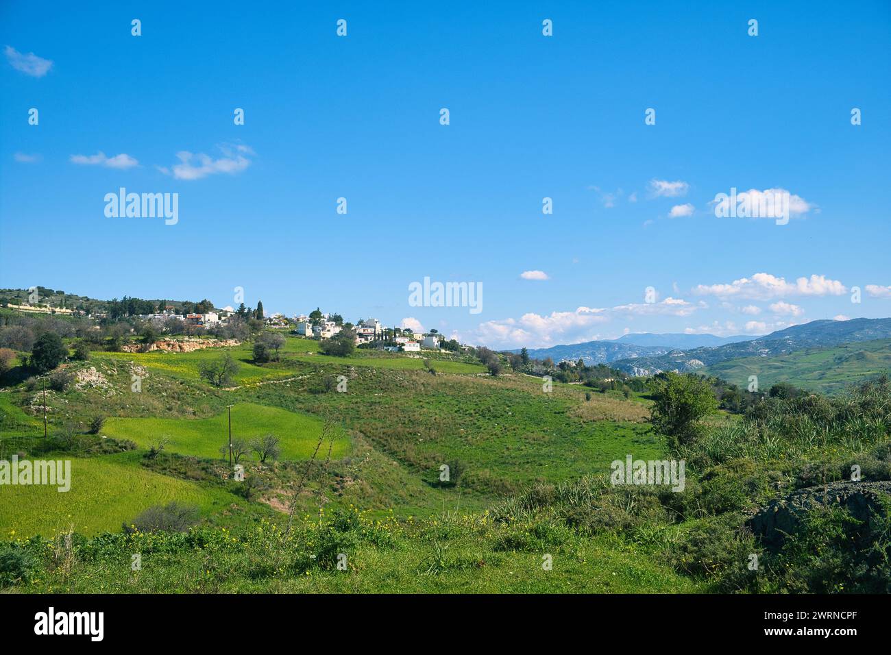 Landscape with green fields, mountains and a village near Nata, district of Paphos (Pafos), Cyprus, on a sunny day Stock Photo