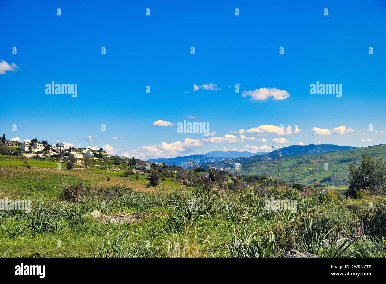 Landscape with green fields, mountains and a village near Nata, district of Paphos (Pafos), Cyprus, on a sunny day Stock Photo