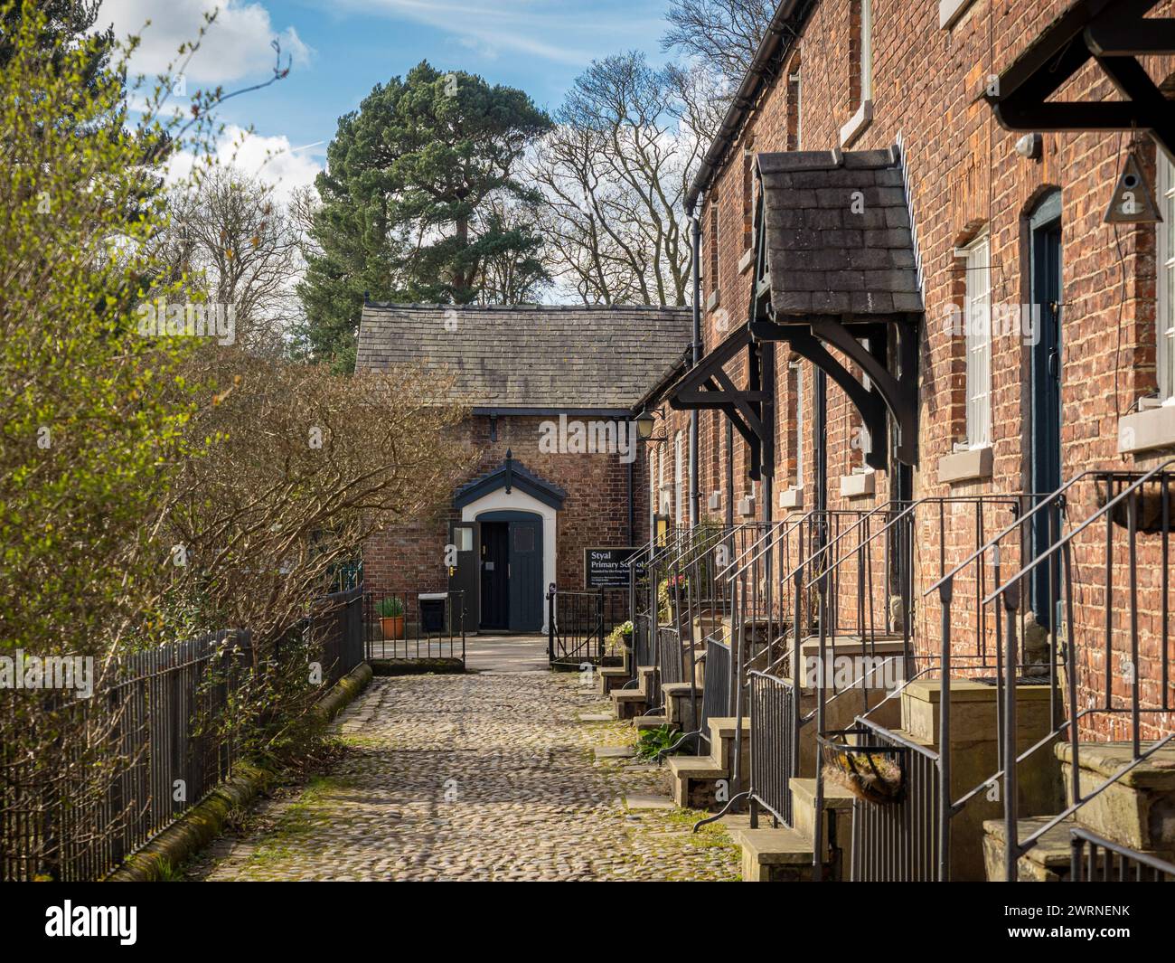 Traditional cottages along a cobble lane with the village primary ...