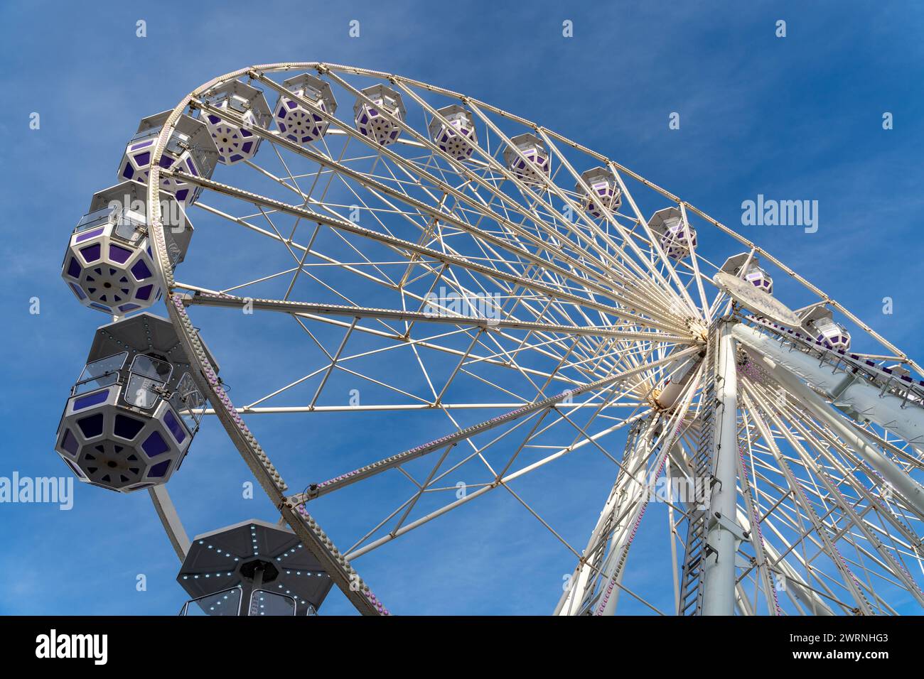 Southampton, England - December 8, 2023: Ferris wheel ride with gondolas in front of a blue sky in Southampton, England *** Riesenrad Fahrgeschäft mit Gondeln vor blauem Himmel in Southampton, England Stock Photo
