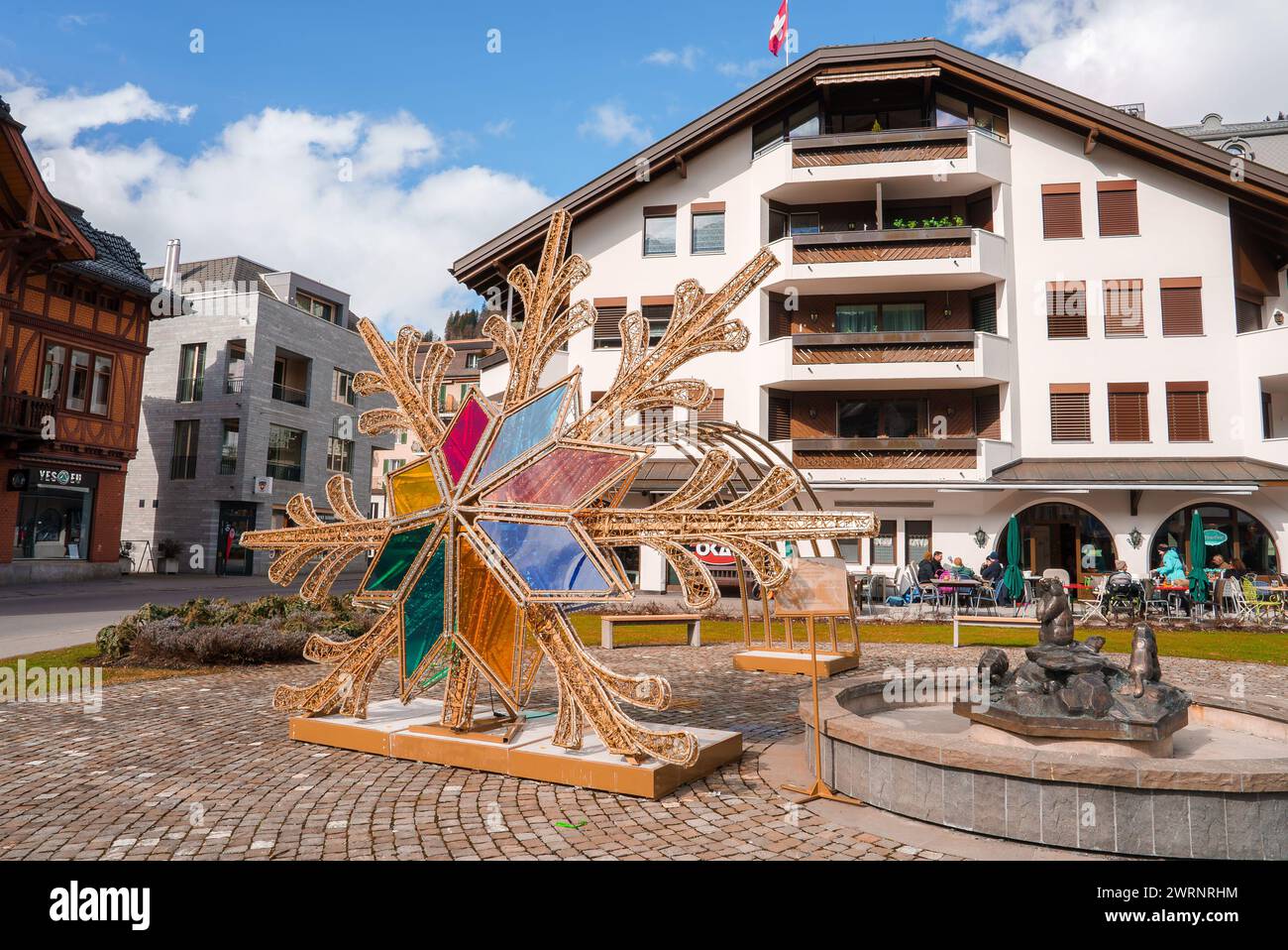 Sunny Day at Engelberg Town Square with Artistic Snowflake Sculpture Stock Photo