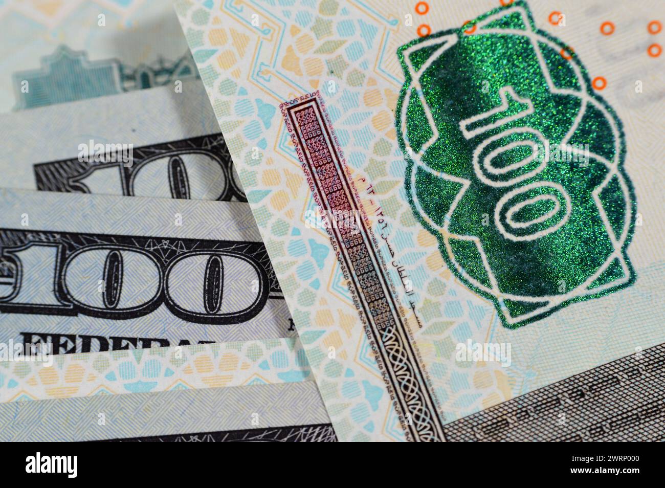 Closeup Egyptian money banknotes of 100 EGP LE one hundred pounds bill and USD American cash of 100 dollars, money exchange rates of Egypt and United Stock Photo