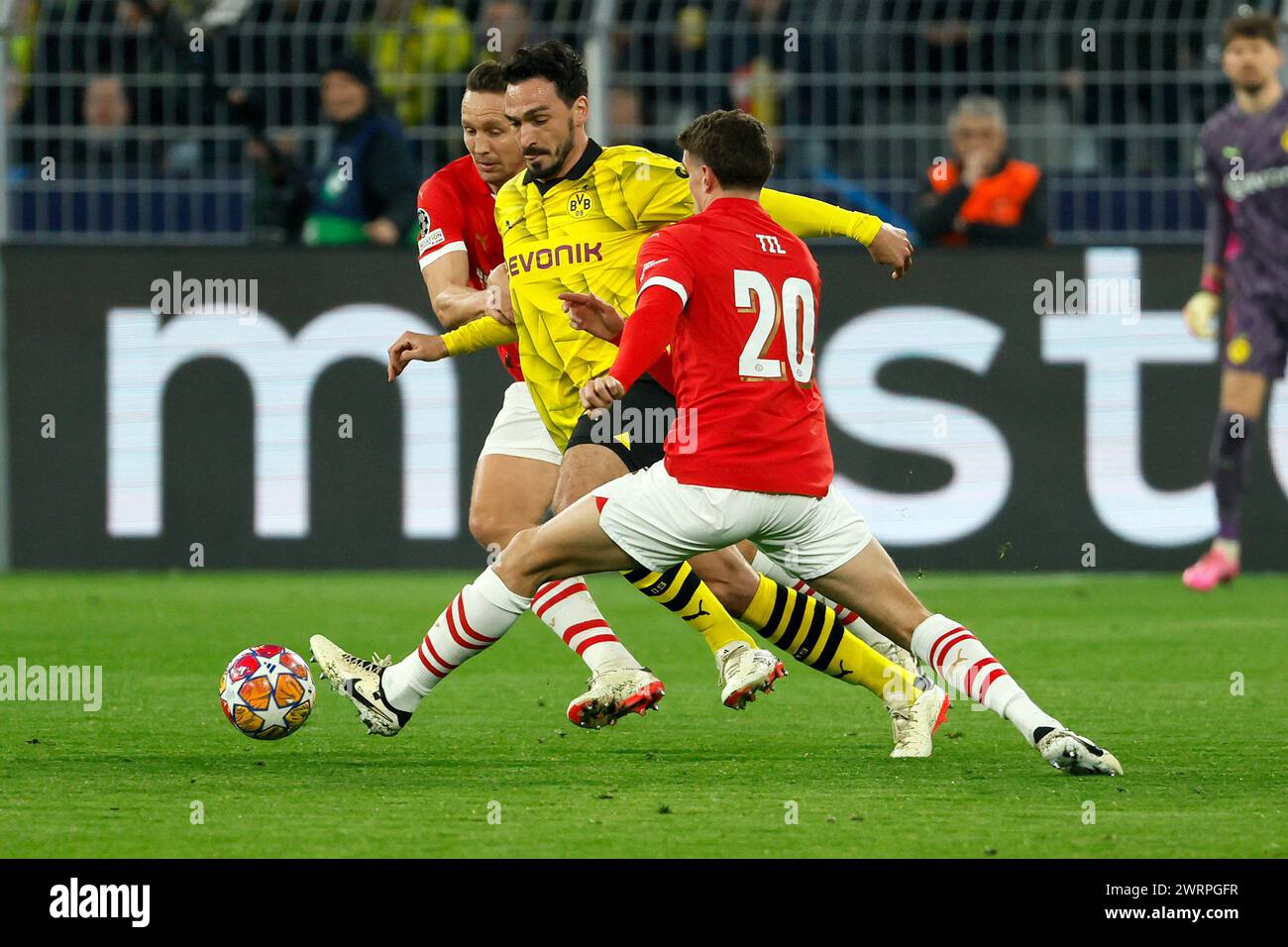 Dortmund, Germany. 13th Mar, 2024. Mats Hummels (C) of Borussia Dortmund vies with Luuk De Jong (L) and Guus Til of PSV Eindhoven during the UEFA Champions League round of 16 match in Dortmund, Germany, March 13, 2024. Credit: Joachim Bywaletz/Xinhua/Alamy Live News Stock Photo
