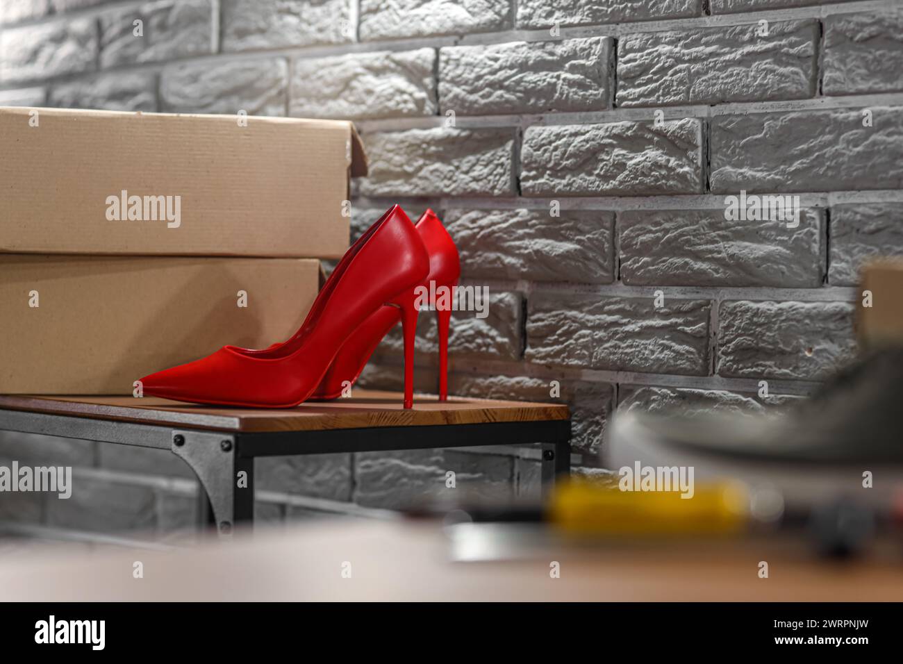 Red heels on shelf in shoemaker's workshop, closeup Stock Photo